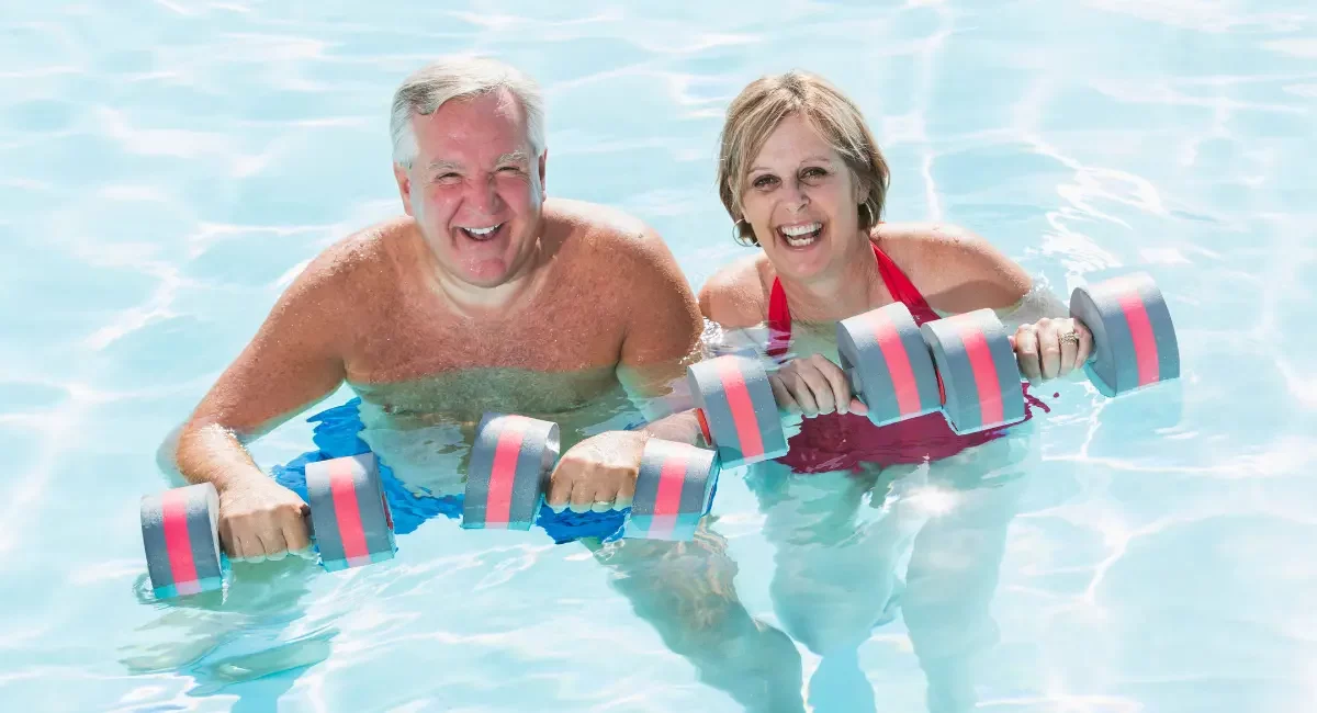 Picture of a couple in their inground pool trying new pool exercises.